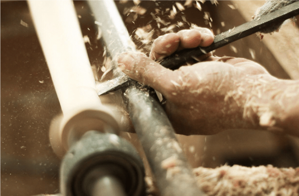 Close up at factory worker's hand while carving wood